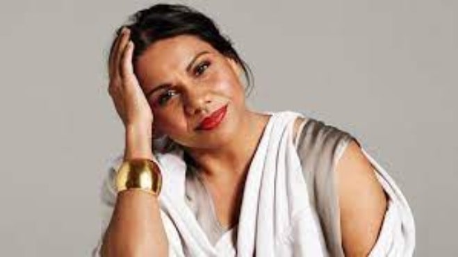 Deborah Mailman posing for a photo by wearing white dress.